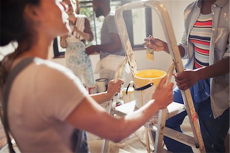 Women with yellow paint painting living room Stock Photo - Premium Royalty-Free, Code: 6113-09059366