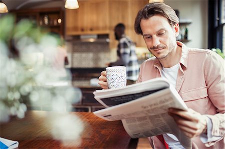 simsearch:6113-07790487,k - Man drinking coffee and reading newspaper in kitchen Photographie de stock - Premium Libres de Droits, Code: 6113-09059394
