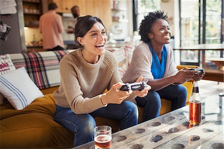 simsearch:6113-08927779,k - Laughing women friends playing video game on living room sofa Photographie de stock - Premium Libres de Droits, Code: 6113-09059396