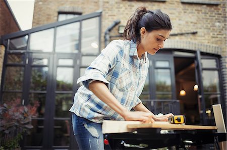 Young woman measuring wood on patio Photographie de stock - Premium Libres de Droits, Code: 6113-09059301