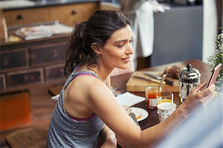 french press coffee maker - Young woman texting with smart phone at breakfast table Stock Photo - Premium Royalty-Free, Code: 6113-09059317