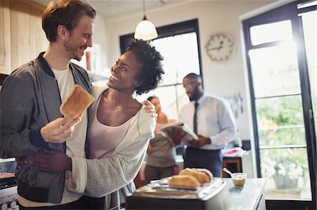 simsearch:6113-07565759,k - Affectionate couple hugging and eating toast in morning kitchen Stock Photo - Premium Royalty-Free, Code: 6113-09059402