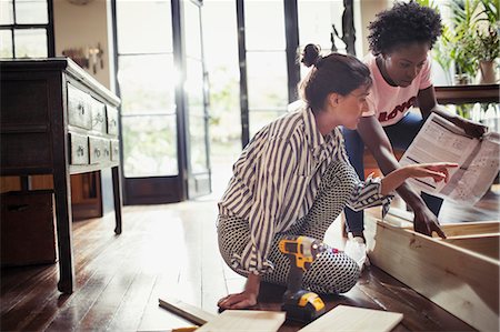 Women with instructions assembling furniture Stock Photo - Premium Royalty-Free, Code: 6113-09059407