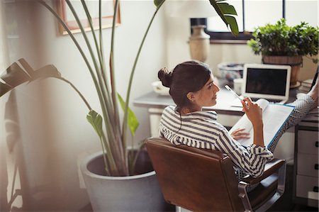 freelancer - Businesswoman reading paperwork with feet up on desk Stock Photo - Premium Royalty-Free, Code: 6113-09059412