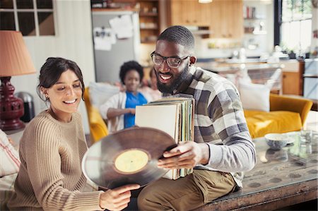 Couple looking at vinyl records in living room Stock Photo - Premium Royalty-Free, Code: 6113-09059435