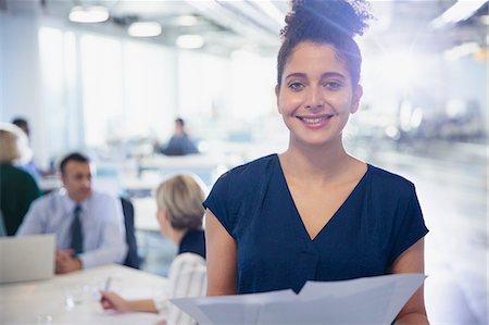 simsearch:6113-08105408,k - Portrait smiling, confident young businesswoman with paperwork in office Foto de stock - Royalty Free Premium, Número: 6113-09004955