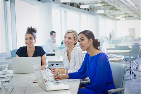 simsearch:6113-09005046,k - Businesswomen at laptops listening in office meeting Photographie de stock - Premium Libres de Droits, Code: 6113-09004980