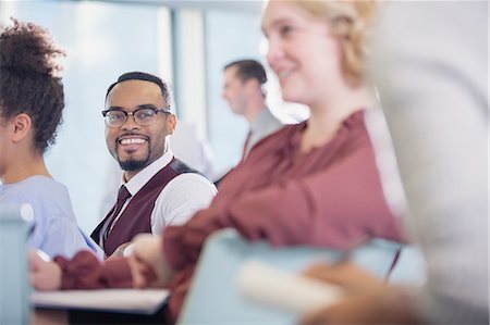 simsearch:6113-09004919,k - Smiling businessman listening in conference audience Fotografie stock - Premium Royalty-Free, Codice: 6113-09004996