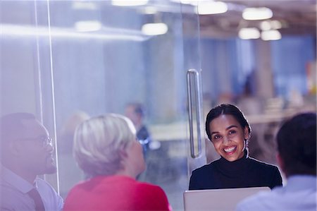 Smiling businesswoman using laptop in conference room meeting Stock Photo - Premium Royalty-Free, Code: 6113-09004927