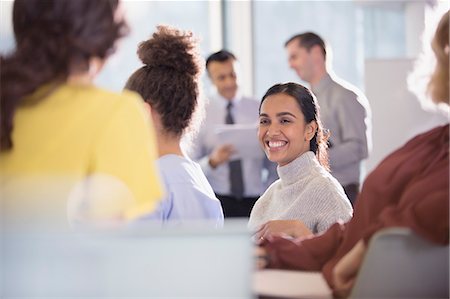 simsearch:6113-09004908,k - Smiling businesswoman talking to colleagues in conference audience Foto de stock - Sin royalties Premium, Código: 6113-09005049