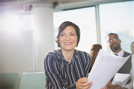 simsearch:6113-06908856,k - Smiling businesswoman with paperwork in conference room meeting Foto de stock - Royalty Free Premium, Número: 6113-09005017