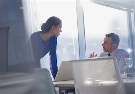 simsearch:6113-07147987,k - Businessman and businesswoman using laptop, talking in office Foto de stock - Royalty Free Premium, Número: 6113-09005022