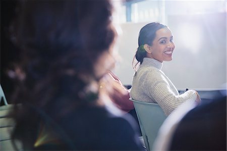 simsearch:6113-07565956,k - Smiling businesswoman turning, looking back in conference audience Stock Photo - Premium Royalty-Free, Code: 6113-09005031