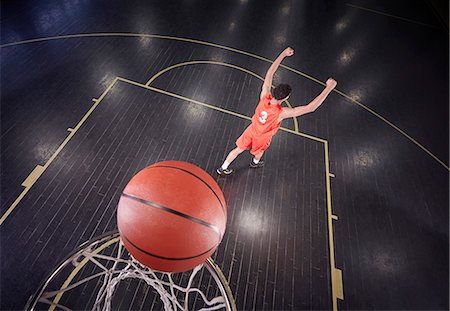 Confident young male basketball player shooting the ball and gesturing, celebrating Stock Photo - Premium Royalty-Free, Code: 6113-09005153