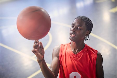 simsearch:6113-09005063,k - Young male basketball player spinning basketball on court Photographie de stock - Premium Libres de Droits, Code: 6113-09005151
