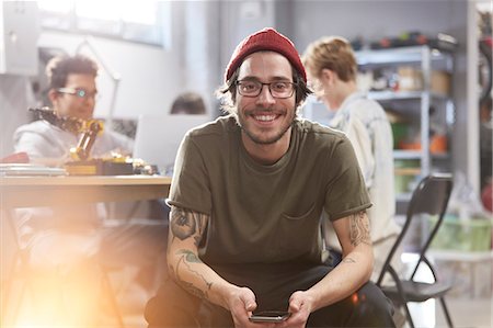 Portrait smiling confident male designer with cell phone Stock Photo - Premium Royalty-Free, Code: 6113-09005166