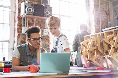 robot - Serious, focused designers working at laptop in workshop Photographie de stock - Premium Libres de Droits, Code: 6113-09005172