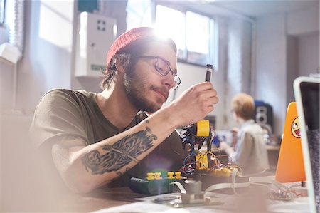 robotique - Focused young male designer assembling robotics in workshop Photographie de stock - Premium Libres de Droits, Code: 6113-09005175