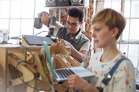 project development - Designers using laptop and power drill in workshop Stock Photo - Premium Royalty-Free, Code: 6113-09005191