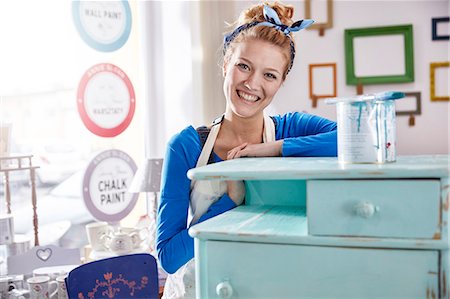 Portrait smiling, confident female artist painting side table blue in art class workshop Stock Photo - Premium Royalty-Free, Code: 6113-09005252