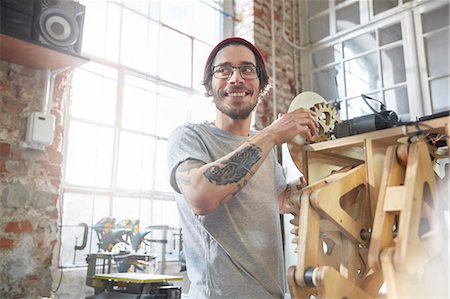 Male designer with tattoos working on prototype in workshop Photographie de stock - Premium Libres de Droits, Code: 6113-09005202