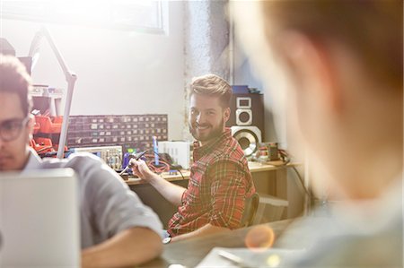 simsearch:6113-09005207,k - Portrait smiling engineer assembling electronics, using soldering iron in workshop Stock Photo - Premium Royalty-Free, Code: 6113-09005220