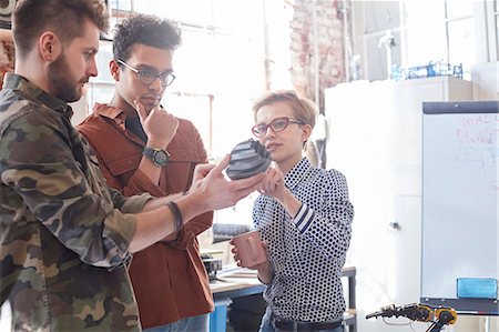 Designers meeting, examining prototype in workshop Stock Photo - Premium Royalty-Free, Code: 6113-09005235