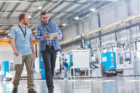 production meeting - Male supervisor and worker with digital tablet talking and walking in factory Stock Photo - Premium Royalty-Free, Code: 6113-09005341