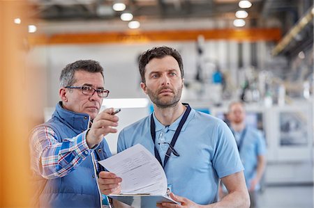 simsearch:649-07804440,k - Serious male supervisors with clipboard talking in factory Stock Photo - Premium Royalty-Free, Code: 6113-09005353