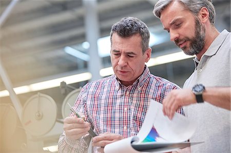 simsearch:693-05794216,k - Male supervisors with clipboard examining fiber optic cable in factory Stock Photo - Premium Royalty-Free, Code: 6113-09005350