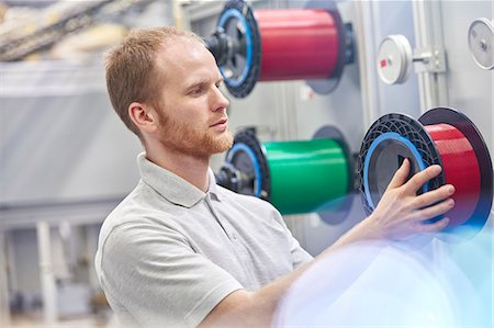 simsearch:6113-07160309,k - Male worker changing spool in fiber optics factory Stock Photo - Premium Royalty-Free, Code: 6113-09005356