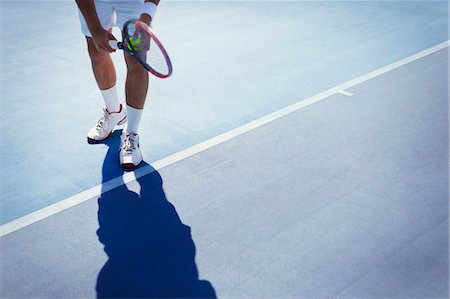 simsearch:6113-09005080,k - Young male tennis player preparing to serve the ball on sunny blue tennis court Foto de stock - Sin royalties Premium, Código: 6113-09005377