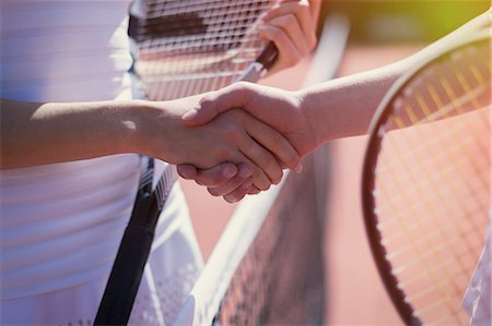 Close up tennis players handshaking in sportsmanship at net Stock Photo - Premium Royalty-Free, Code: 6113-09005376