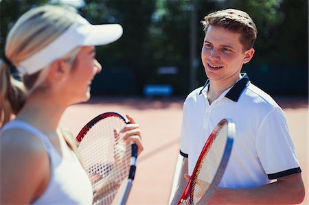 Male and female tennis players talking, holding tennis rackets Stock Photo - Premium Royalty-Free, Code: 6113-09005387