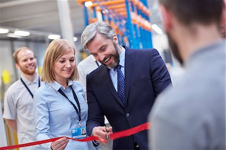 ribbon - Businessman and businesswoman cutting ceremonial ribbon in fiber optics factory Stock Photo - Premium Royalty-Free, Code: 6113-09005318