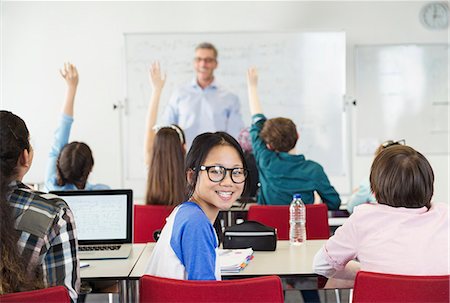 simsearch:6113-09240430,k - Portrait smiling girl student sitting in classroom during lesson Foto de stock - Sin royalties Premium, Código: 6113-09027253