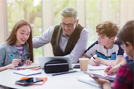 early childhood educator - Male teacher and students researching at laptop in library Stock Photo - Premium Royalty-Free, Code: 6113-09027262