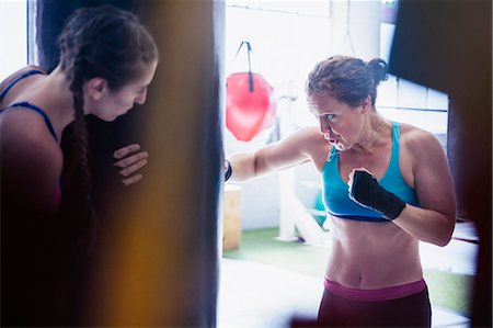 Determined, tough female boxers boxing at punching bag in gym Photographie de stock - Premium Libres de Droits, Code: 6113-09027359