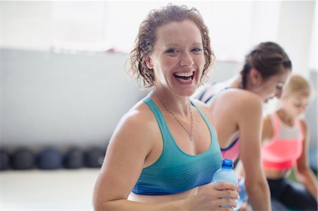 simsearch:6113-08536110,k - Portrait smiling, laughing woman drinking water and resting post workout at gym Stock Photo - Premium Royalty-Free, Code: 6113-09027368