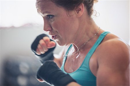 simsearch:6113-09027330,k - Close up determined, tough female boxer shadowboxing Fotografie stock - Premium Royalty-Free, Codice: 6113-09027375
