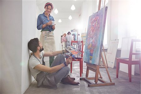 Artists drinking coffee painting at easel in art class studio Stock Photo - Premium Royalty-Free, Code: 6113-09027441