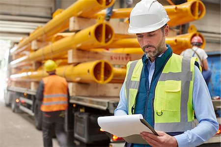 simsearch:6113-08943944,k - Male foreman reading paperwork on clipboard in factory Stock Photo - Premium Royalty-Free, Code: 6113-09027544