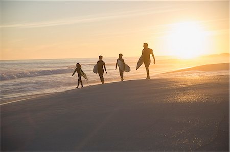 Silhouette family surfers walking with surfboards on sunny summer sunset beach Stock Photo - Premium Royalty-Free, Code: 6113-09027640