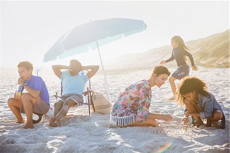 squat - Multi-ethnic family relaxing and playing on sunny summer beach Photographie de stock - Premium Libres de Droits, Code: 6113-09027678