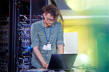 Male IT technician working at laptop in server room Photographie de stock - Premium Libres de Droits, Code: 6113-09027602