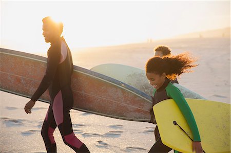 family in the sunset - Family carrying surfboards and boogie boards on sunny summer beach Stock Photo - Premium Royalty-Free, Code: 6113-09027755