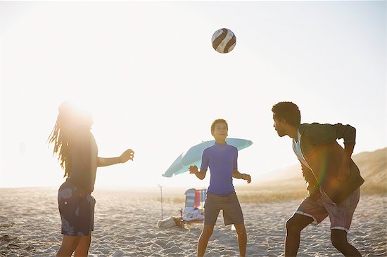 Family playing soccer on sunny summer beach Stock Photo - Premium Royalty-Free, Image code: 6113-09027764