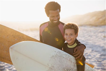 simsearch:614-09210687,k - Portrait smiling father and son surfers carrying surfboards on sunny summer beach Stock Photo - Premium Royalty-Free, Code: 6113-09027776