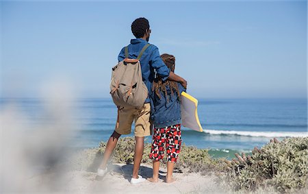 Father and daughter with boogie board looking at ocean on sunny summer beach Stock Photo - Premium Royalty-Free, Code: 6113-09027715