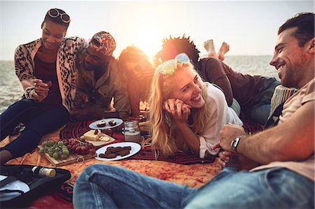 eating on the beach - Young friends hanging out, enjoying picnic on sunny summer beach Stock Photo - Premium Royalty-Free, Code: 6113-09027861